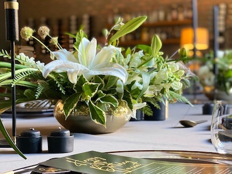 Wooden dinner table with candles and dried flower arrangement