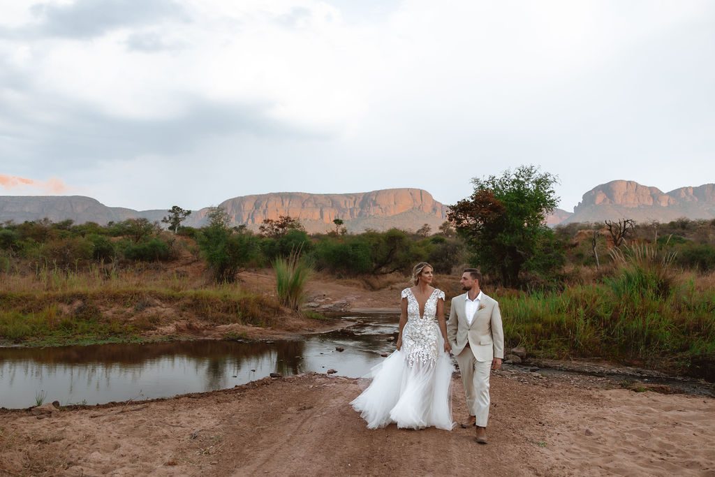 Bridal couple walking in the wilderness at a safari lodge